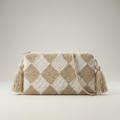 Bolso de mano artesanal tipo clutch con diseño de rombos en relieve textura "punch needle", colores crema y arena con borlas y cordón trenzado.