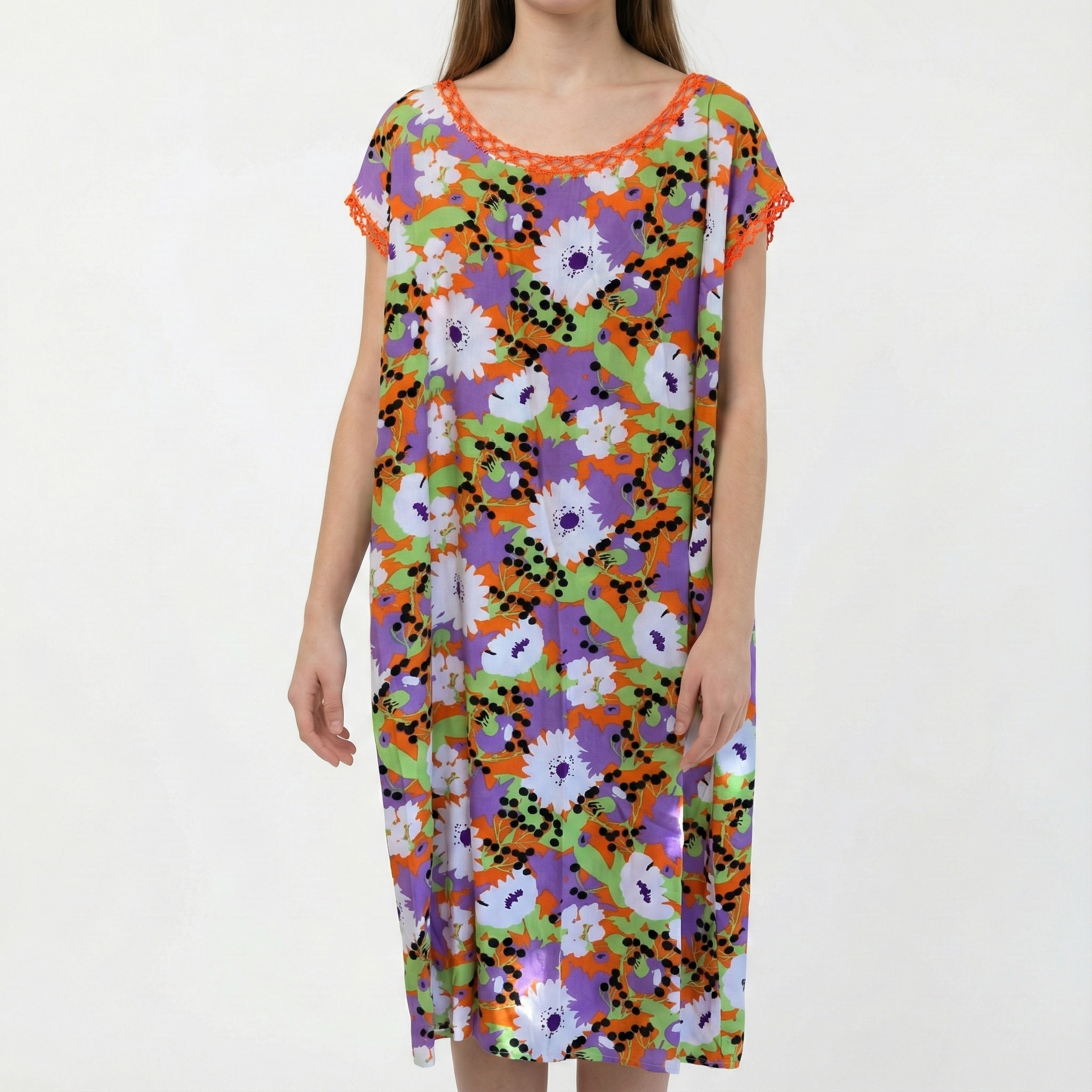 Manta Wayuu para mujer con estampado de flores grandes en colores naranja, violeta y verde, destacando un cuello tejido artesanalmente en color naranja.