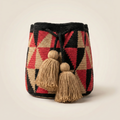 Mochila Wayuu artesanal con diseño de rombos geométricos en colores rojo, negro y arena, con borlas grandes de color beige.