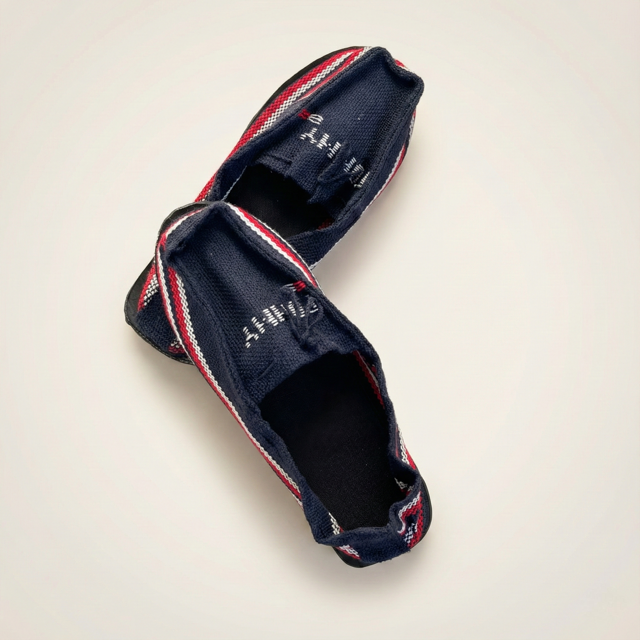 Par de waireñas wayuu auténticas tejidas en hilo azul oscuro con ribete tricolor y suela de llanta.